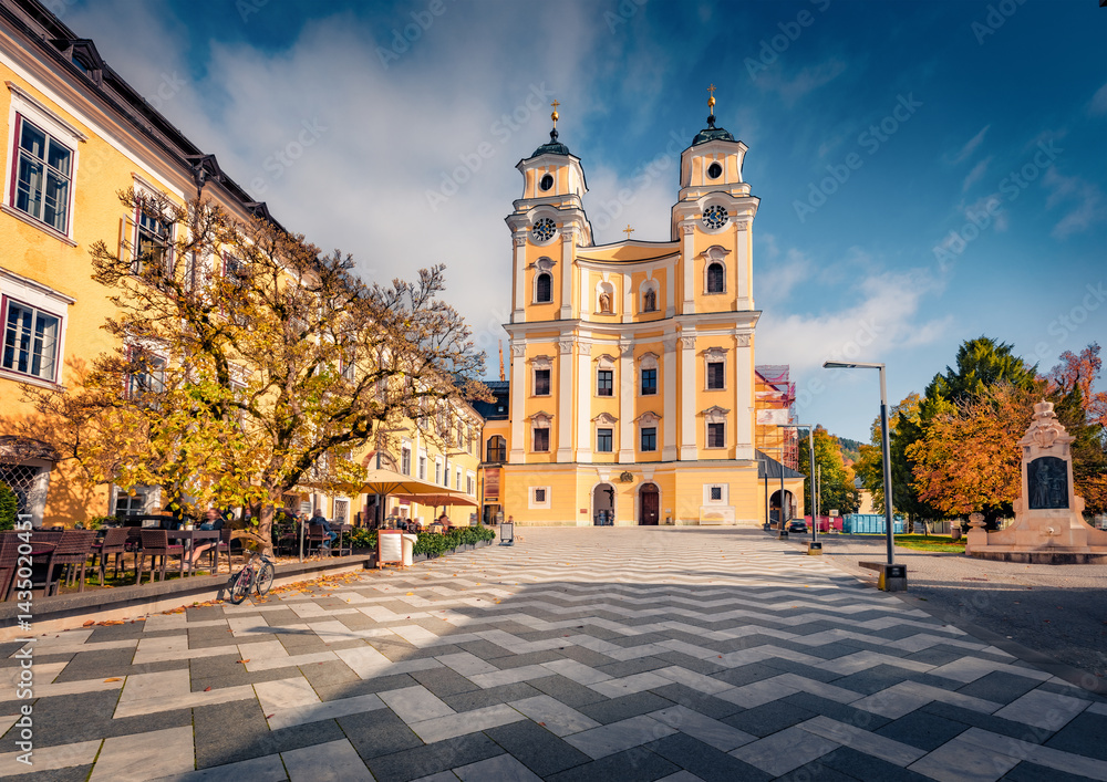 Sunny autumn view of Basilika St. Michael Catholic church. Colorful afternoon cityscape of Mondsee townt, Vocklabruck district in the Austrian state of Upper Austria. Traveling concept background.