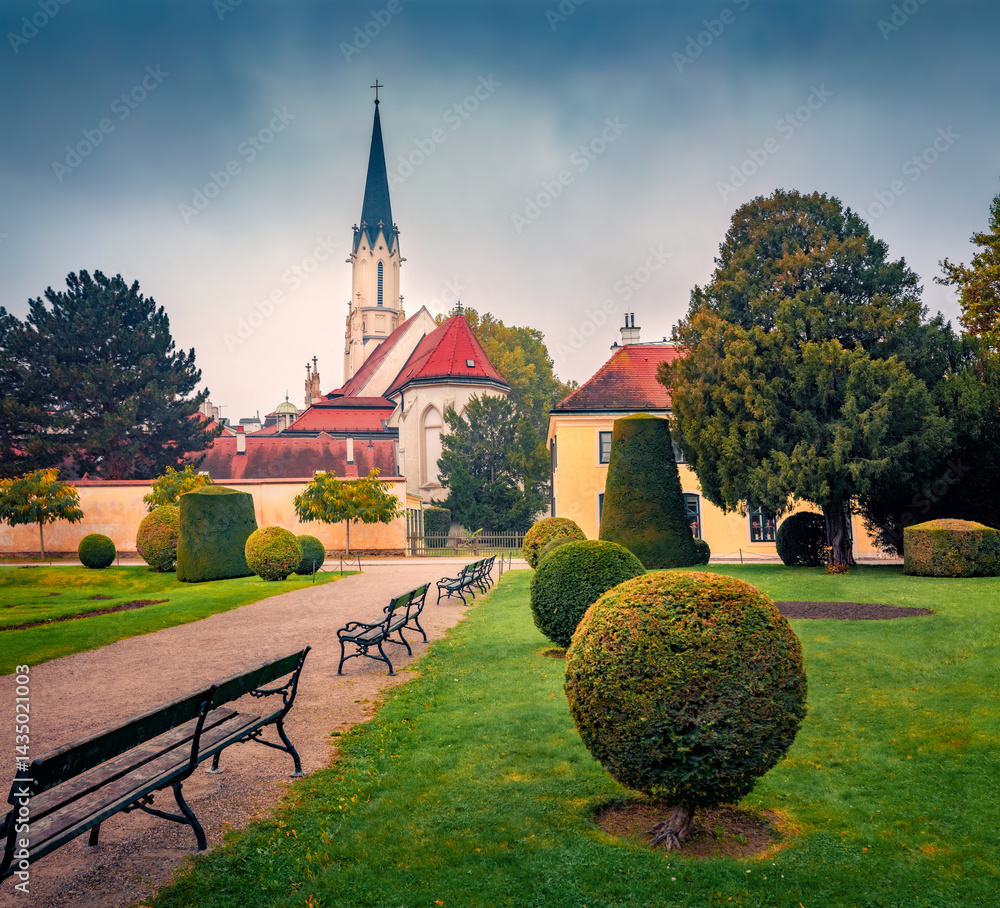 Gloomy autumn view of Hietzing Catholic Church (Maria Geburt). Picturesque morning cityscape of Vienna, capital of Austria, Europe. Nice scene of public city park. Traveling concept background..
