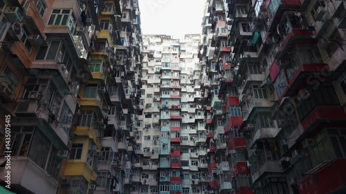 Hong Kong Monster Building showcases a dense residential complex with tightly packed apartments. The video captures the intricate architecture, featuring numerous air conditioning units and colorful