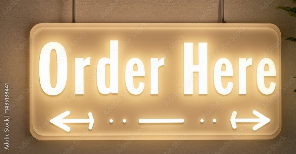 Fototapeta premium Bright sign displays Order Here text. Arrows indicate direction, simple design, warm lighting present.