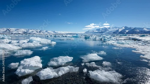 Wallpaper Mural Floating icebergs in glacial lagoon with snowy mountain peaks against clear blue sky. Reflections shimmer in cold water landscape. Torontodigital.ca