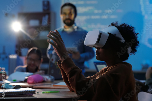 Tableau sur toile Child engaged in virtual reality learning experience in classroom, with teacher