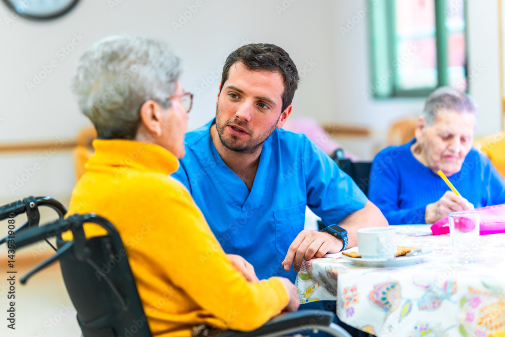 Male nurse assisting elderly woman in wheelchair at nursing home