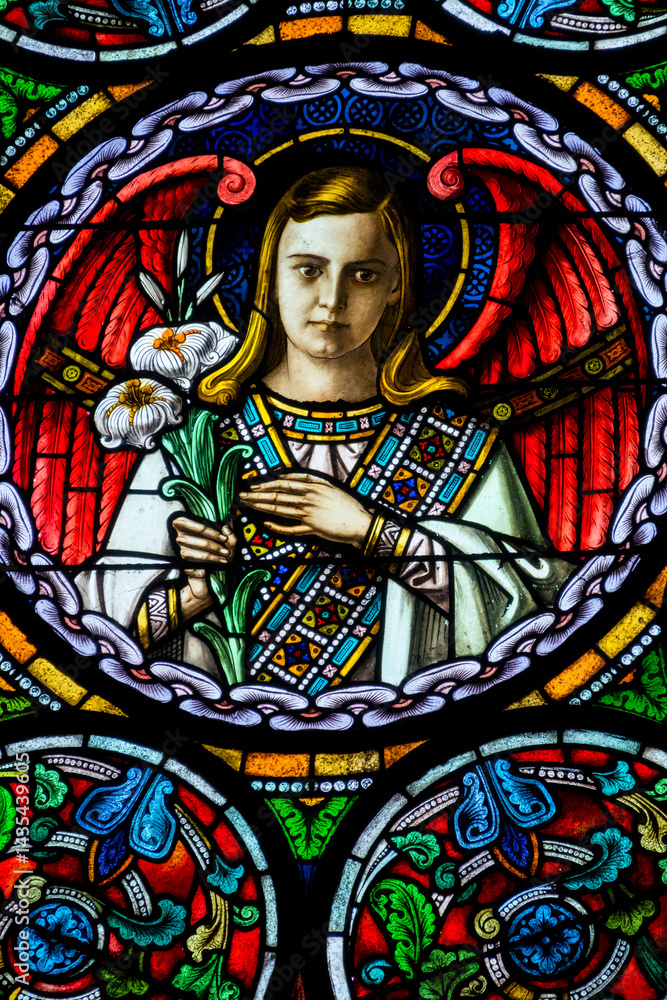 Stained glass (19th century) of an nice angel in heaven with flowers. Stained glass (19th century) of an nice angel in heaven with flowers.