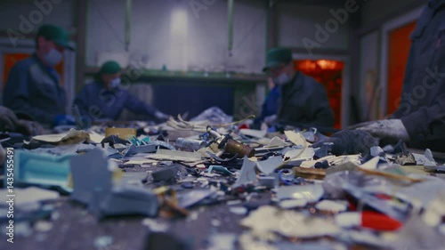 Man sorts garbage, electronics or plastic. Taking care of the environment. Waste recycling plant or garbage factory. Conveyor belt, trash moving along the line. Male have a eco-friendly work