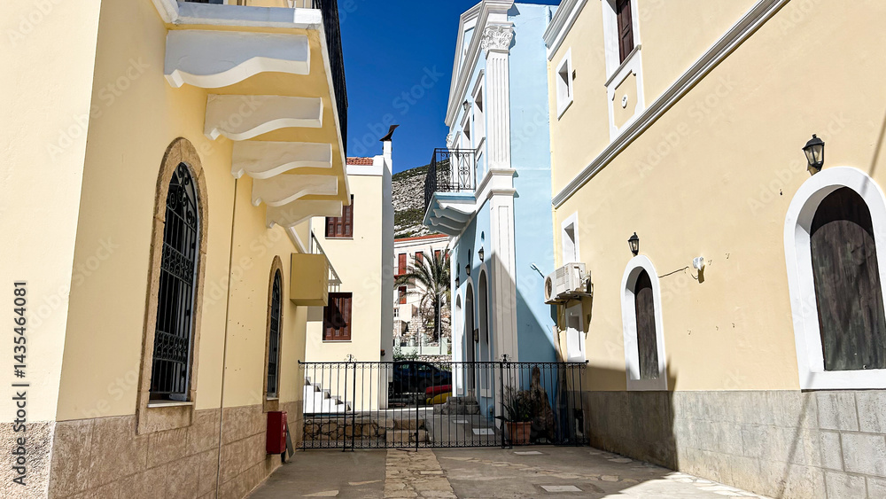 Obraz premium Traditional Mediterranean Alley With Colorful Buildings And Palm Tree In Kastellorizo Island, Greece, On A Sunny Day, Concept Of Historic Architecture, Real Estate, Tourism, Summer Vacation, Cultural 
