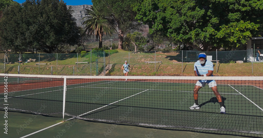 Fototapeta premium Exercise, sport and mature people with racket, performance and playing of game for fitness, healthy and active. Outdoor, training and athlete with equipment for workout, match or confident for tennis