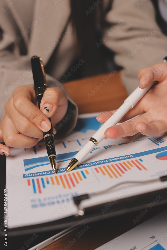 Group of confident business people point to graphs and charts to analyze market data, balance sheet, account, net profit to plan new sales strategies to increase production capacity. Group of confident business people point to graphs and charts to analyze market data, balance sheet, account, net profit to plan new sales strategies to increase production capacity.