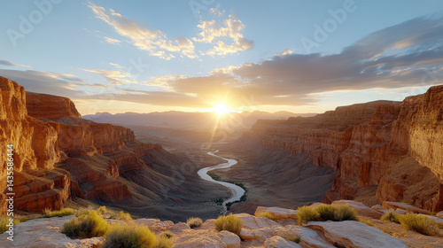 Fototapeta Naklejka Na Ścianę i Meble -  Golden sunset over wide desert canyon with deep shadows and winding river below