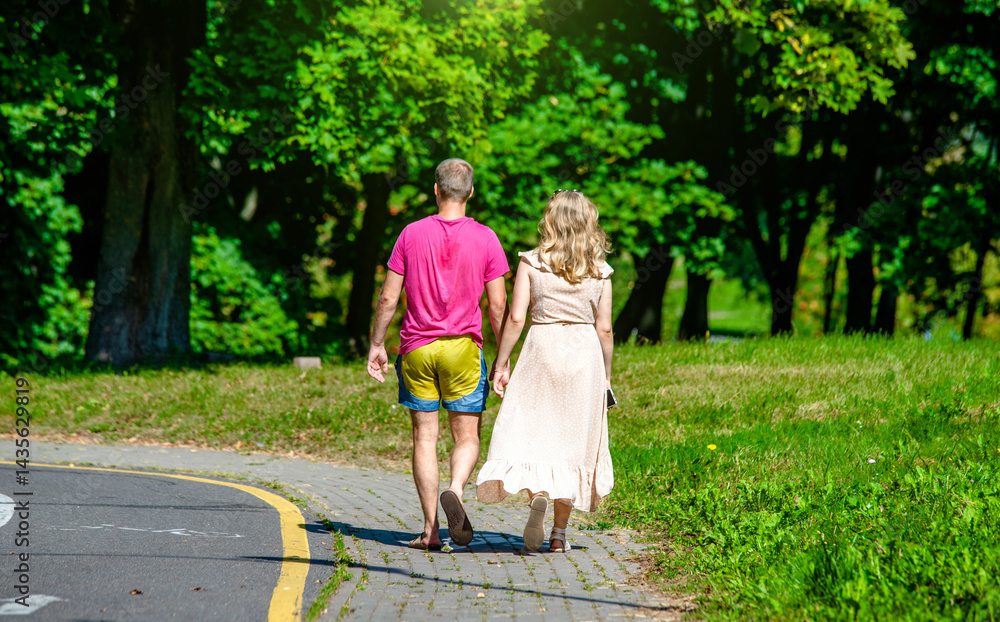Fototapeta premium A man and a woman walk in a summer park