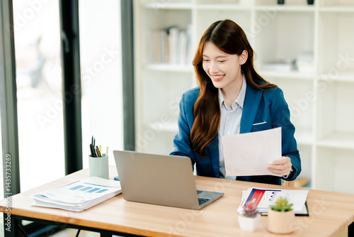 Young Asian woman doing financial accounting and taxes for a company Organizing account analysis reports Investment information Financial and tax system concepts