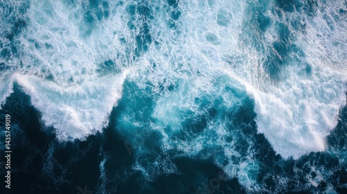 An aerial view of ocean waves crashing, showcasing the vibrant blues and foamy white caps, capturing the beauty and power of nature.