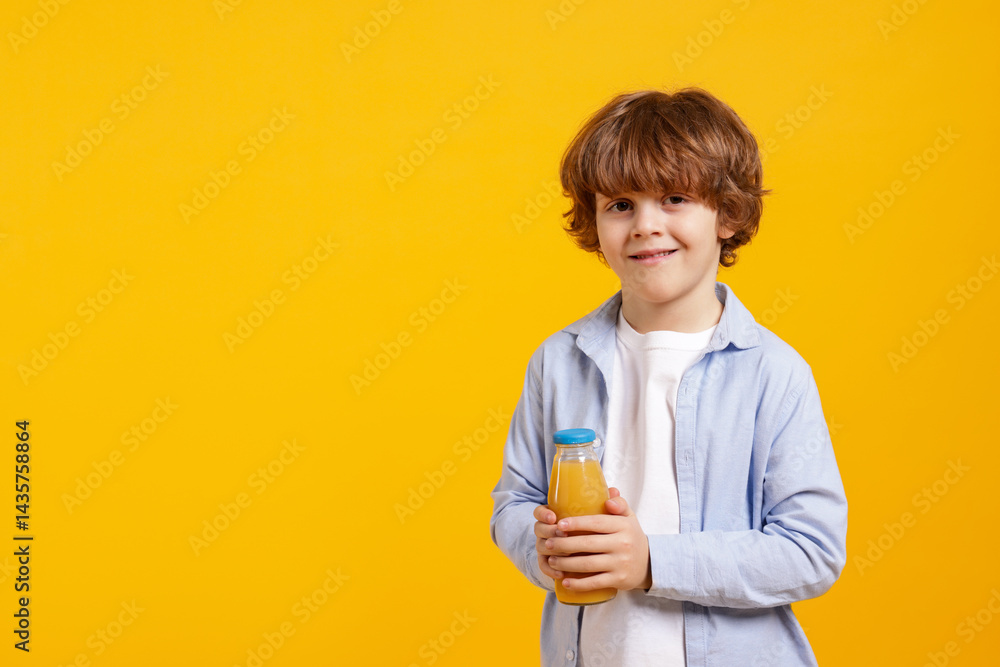Little boy with drink on orange background. Space for text Little boy with drink on orange background. Space for text