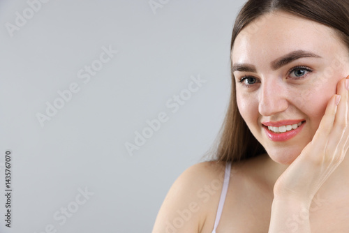 Smiling woman with healthy skin on grey background. Space for text