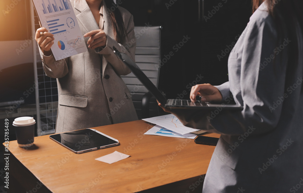 Fototapeta premium Group of confident business people point to graphs and charts to analyze market data, balance sheet, account, net profit to plan new sales strategies to increase production capacity.