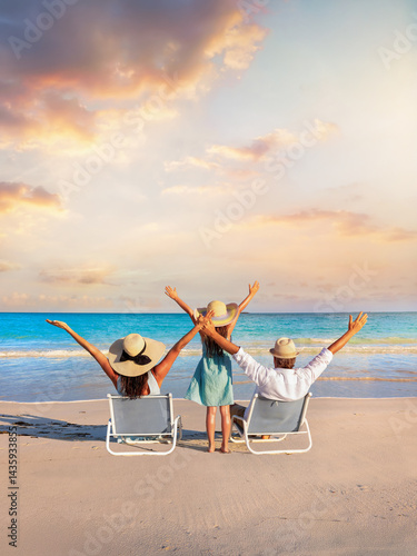 Obraz na płótnie A happy family on summer holidays sits on a tropical beach and enjoys together the beautiful sunset w salonie