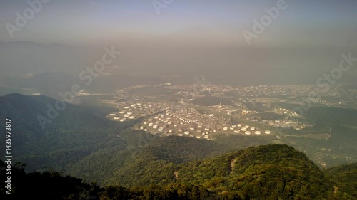 Industrial plant, fuel tanks and petrochemicals in aerial view. Steel giants amidst the complex structure. Pulsating energy and fog.