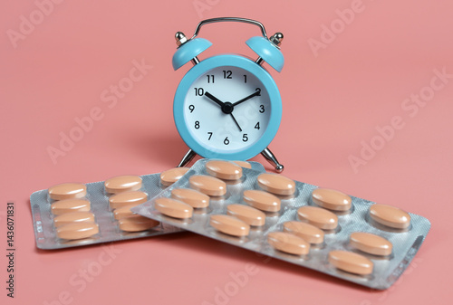 Blisters of pills lie in front of the alarm clock. Healthcare concept.