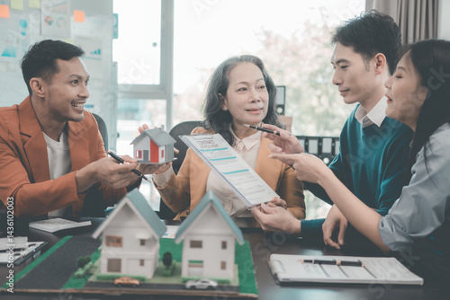 Business team signing investment agreement for residential real estate. Group of professionals in suits meeting in office with financial agreement documents on table.