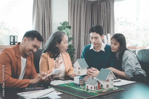 Business team signing investment agreement for residential real estate. Group of professionals in suits meeting in office with financial agreement documents on table.