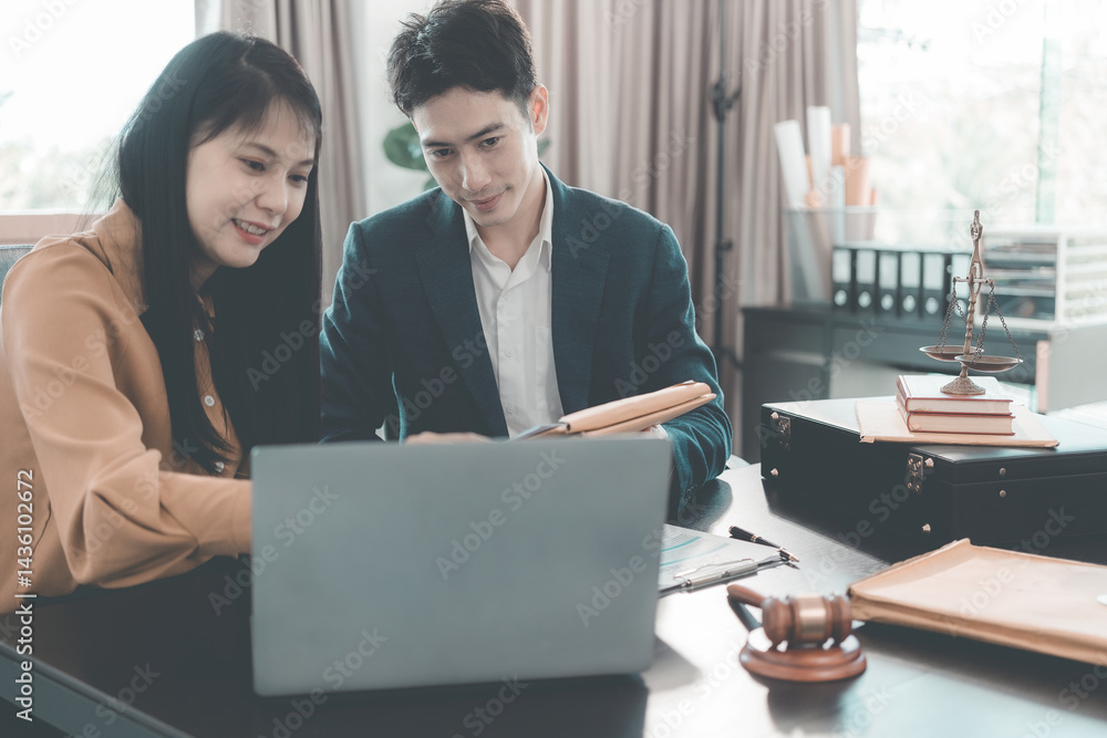 Male and female lawyers discussing documents at conference table in meeting with contract documents and wooden hammer on table in courtroom. Justice and law. Lawyer.