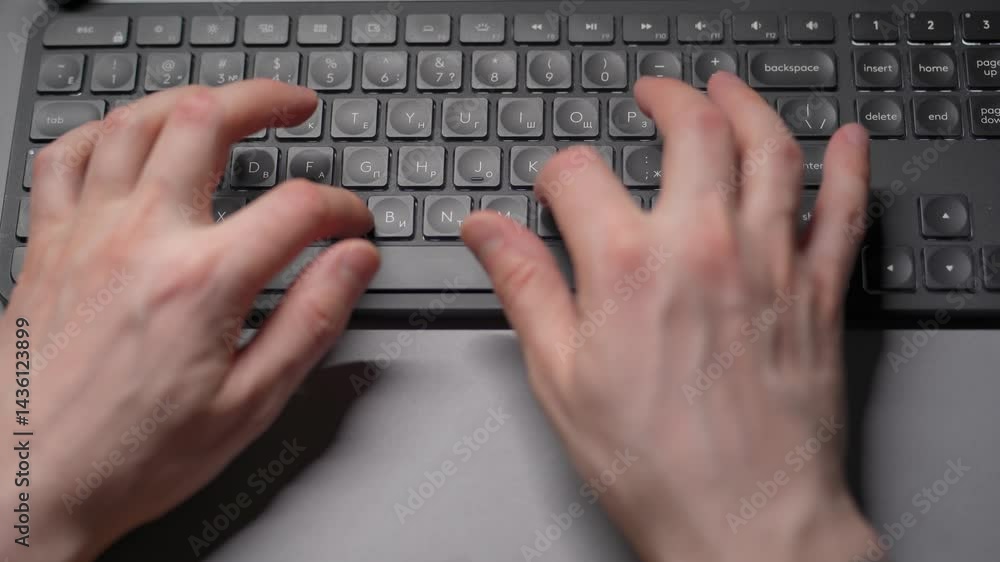 Close-up view of fingers on a keyboard from above. A person typing on the keyboard. Close-up view of fingers on a keyboard from above. A person typing on the keyboard.