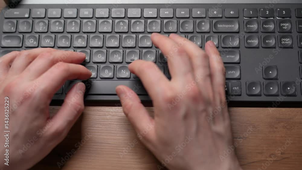 Close-up view of fingers on a keyboard from above. A person typing on the keyboard. Close-up view of fingers on a keyboard from above. A person typing on the keyboard.