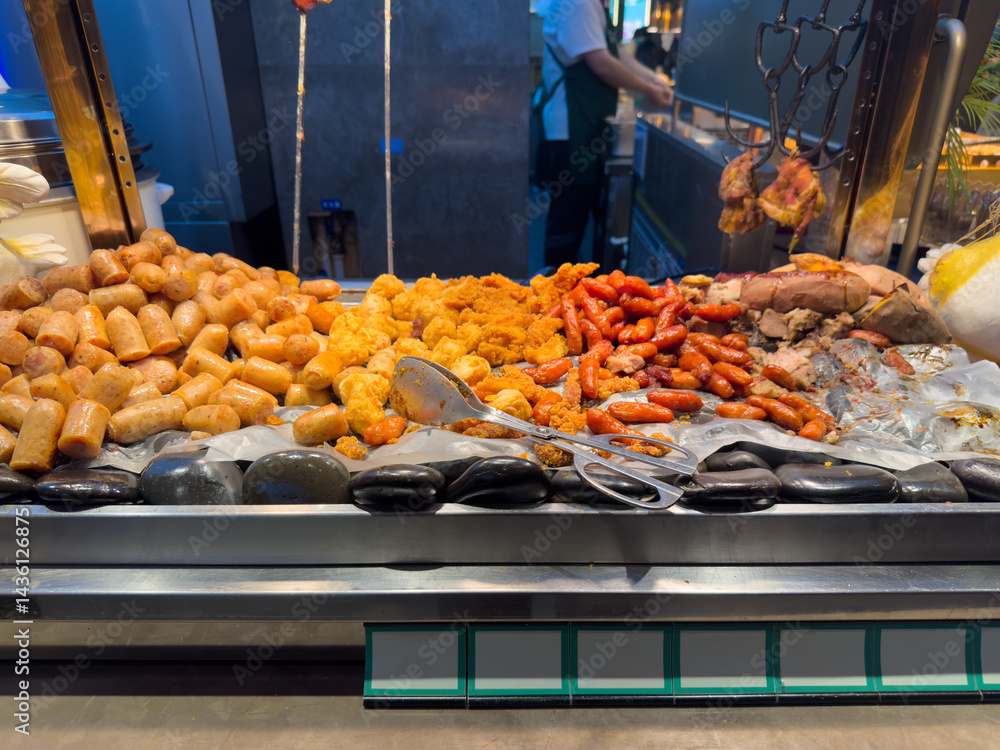 Street food stall, China. Cooked meats variety on a market display. Sausages, chicken nuggets, meat skewers