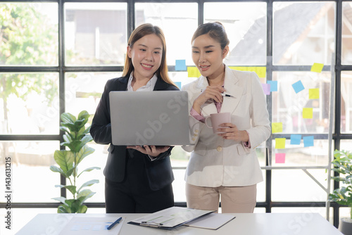 Wallpaper Mural Two Asian businesswomen are discussing their business. While pointing at the graphs and charts on the table, enjoy the success and teamwork in business analysis. Torontodigital.ca