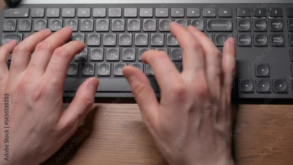 Close-up view of fingers on a keyboard from above. A person typing on the keyboard. Close-up view of fingers on a keyboard from above. A person typing on the keyboard.