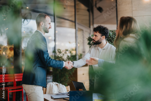 Tableau sur toile Businesspeople shake hands across a table, symbolizing agreement and collaboration in a stylish and contemporary setting
