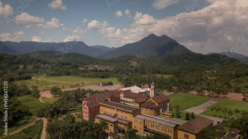 Drone captures a historic church and convent nestled amidst lush tropical mountains. Spiritual sanctuary in nature's embrace