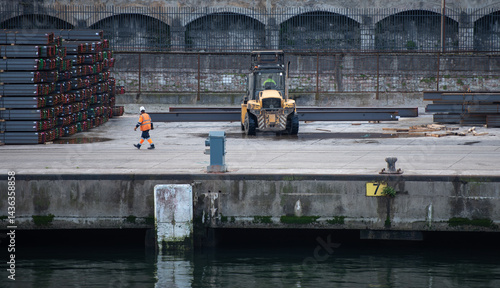 forklift handling steel beams in the port