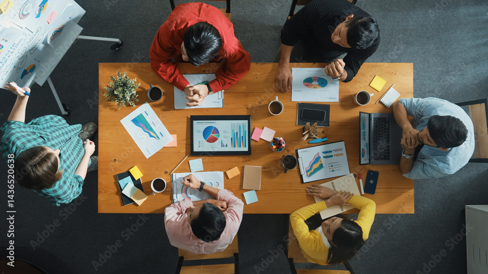 Top view of skilled business people sharing idea about startup project while standing at whiteboard. Business woman hold tablet and placed on meeting room while explain creative idea. Convocation.
