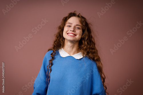 Obraz na płótnie Happy young adult woman wearing winter blue sweater indoors looking at camera with joyful smile w salonie