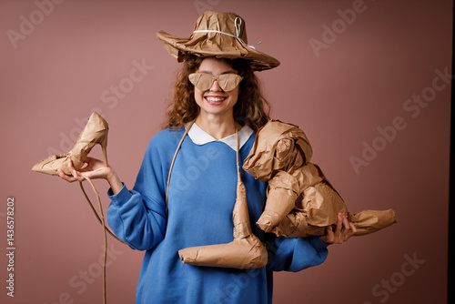 Obraz na płótnie Young positive smiling woman receives surprise gift and holding in hands bunch of gifts wrapped in rustic beige craft paper. Hat, shoes, hair dryer, soft toy and glasses w salonie