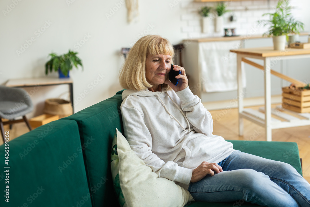 Obraz premium Senior woman talking on the phone at home. C, connection, and cozy living
