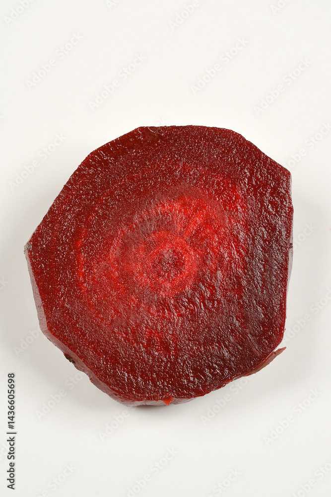 A halved cooked and peeled beetroot sits on a plain white plate