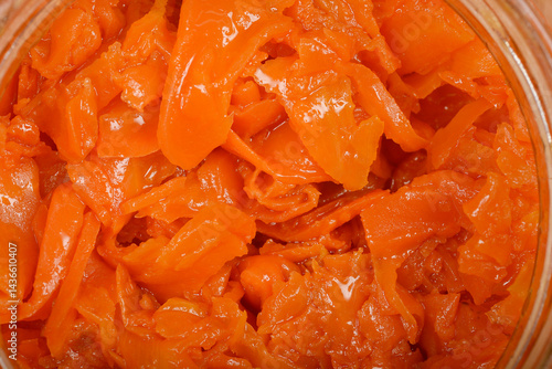 Obraz na płótnie A detailed macro shot showcases the vibrant orange, thinly sliced texture of carrots prepared as vegan salmon inside a clear glass jar w salonie