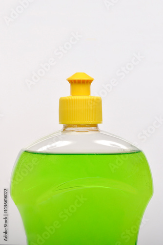 Obraz na płótnie A close-up shot shows a clear plastic bottle filled with bright green dish soap and capped with a yellow lid w salonie
