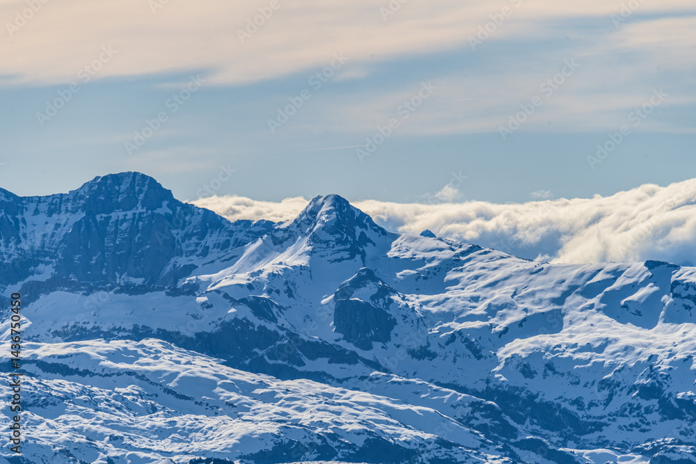 Snow-capped mountains under a clear sky showcasing their majestic peaks and tranquil beauty during winter season Snow-capped mountains under a clear sky showcasing their majestic peaks and tranquil beauty during winter season
