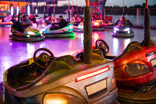 Obraz na płótnie Colorful bumper car ride at a funfair during sunset with neon lights. Blurred background w salonie