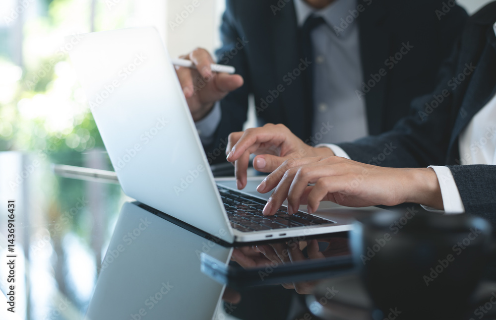 Two asian business persons working together. Businessman brainstorming, having a discussion with his colleague about work project, working on laptop computer at modern office. Business teamwork Two asian business persons working together. Businessman brainstorming, having a discussion with his colleague about work project, working on laptop computer at modern office. Business teamwork
