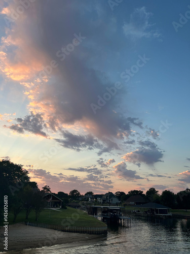 Colorful sunset clouds over Cedar Creek Reservoir waterfront in Texas