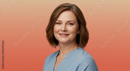 Portrait of a smiling woman with short brown hair against an orange gradient