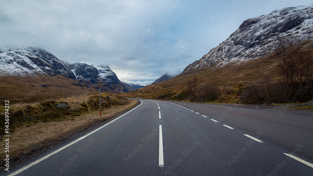 Naklejka premium A breathtaking panoramic view of the Scottish Highlands, featuring snow-capped mountains rising above vast open moorland and rugged terrain.