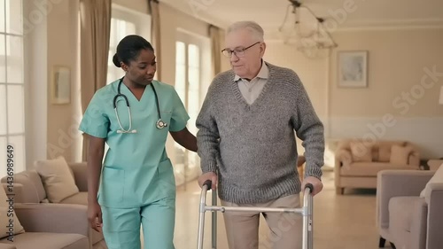 A caregiver assists an elderly man using a walker indoors