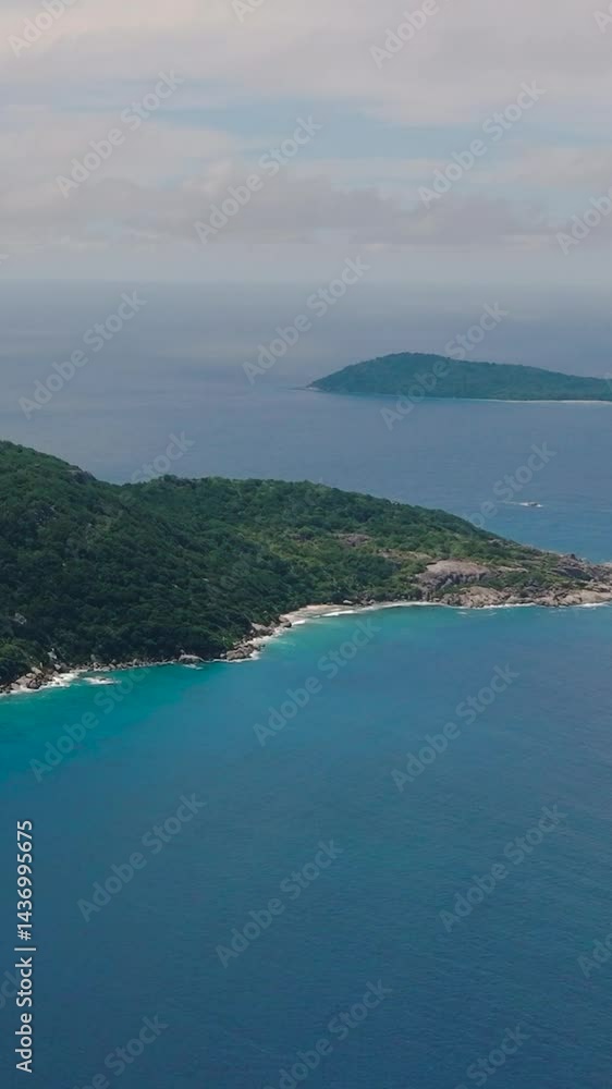 Small islands in the ocean under a partly cloudy sky, surrounded by vast blue waters. Felicite, Seychelles. Small islands in the ocean under a partly cloudy sky, surrounded by vast blue waters. Felicite, Seychelles.