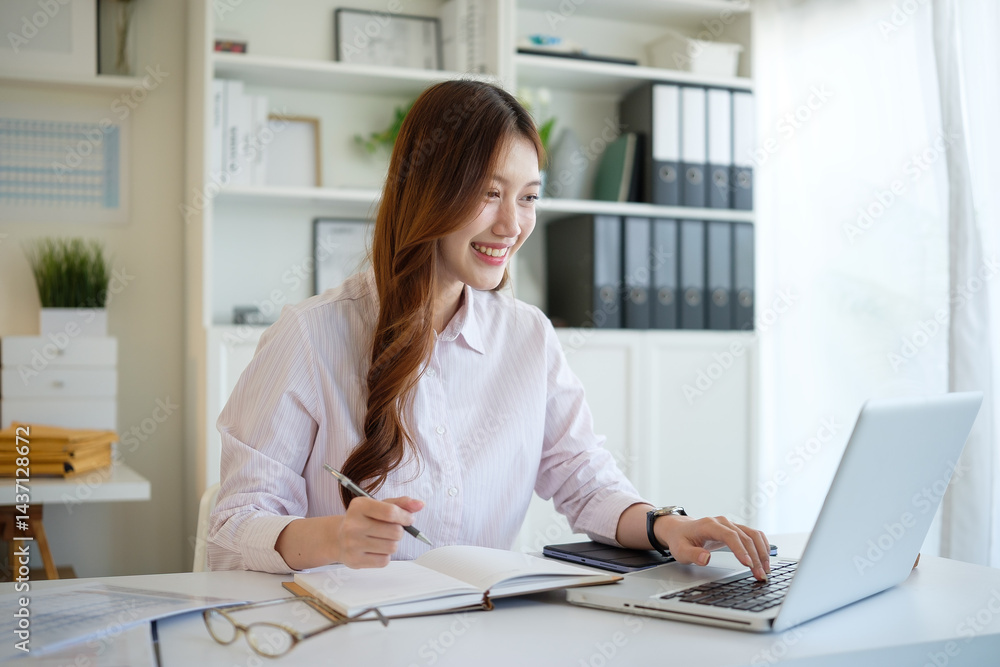 Asian businesswoman planning or journaling in a bright workspace. Asian businesswoman planning or journaling in a bright workspace.