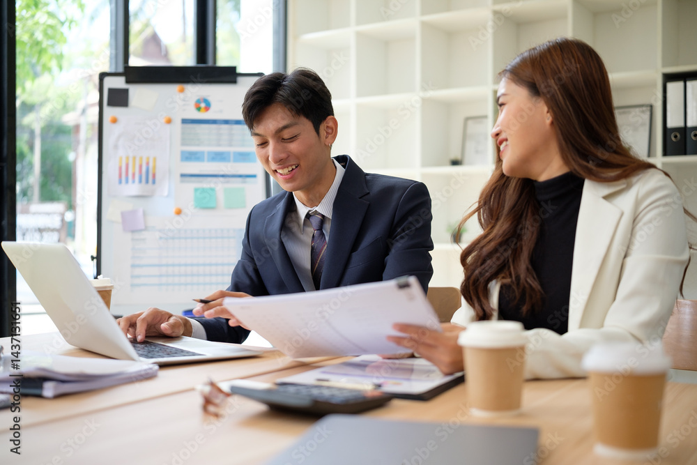 Professional colleagues discussing financial charts and data at a meeting table, smiling and engaged in teamwork. Professional colleagues discussing financial charts and data at a meeting table, smiling and engaged in teamwork.